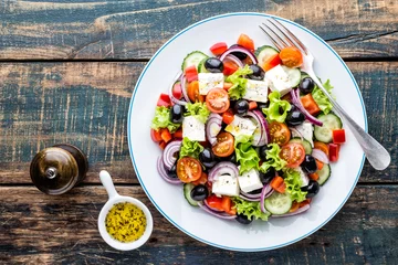  Greek salad of fresh cucumber, tomato, sweet pepper, lettuce, red onion, feta cheese and olives with olive oil. Healthy food, top view © Sunny Forest