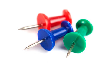 Closeup of Many Colored Thumbtacks on White