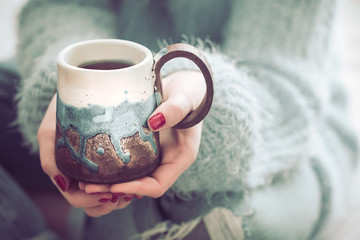 girl holding a cup of tea in hands