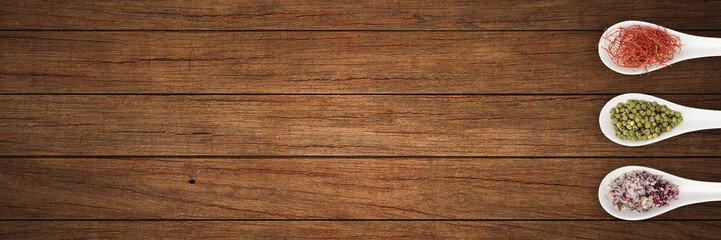 Fototapeta premium Verschiedene Gewürze mit Löffel auf Küchenplatte - Banner | Hintergrund
