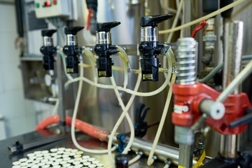 Close-up shot of modern beer bottling equipment at small brewery, no people