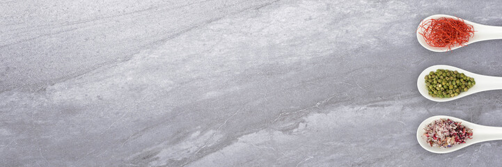 Fototapeta premium Verschiedene Gewürze mit Löffel auf Küchenplatte - Banner | Hintergrund