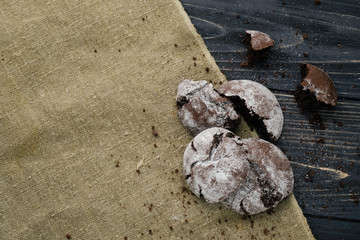 Homemade chocolate cookies on wooden table and textile background