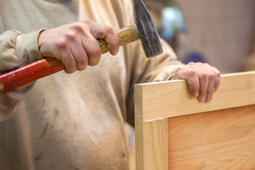 Manual manufacturing of furniture from a natural tree in a workshop.