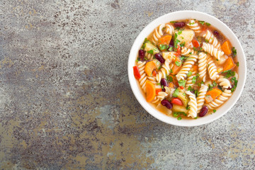 Minestrone soup. Vegetable soup with fresh tomato, celery, carrot, zucchini, onion, pepper, beans and pasta. Dish of italian cuisine.
