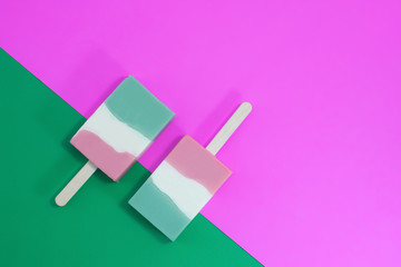 Ice cream sticks on pink and green on background