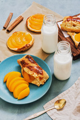Breakfast includes fresh pastries with peach slices and milk.