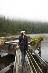 Asian thai woman travel and walking at Waterfront wooden bridge at Mummelsee lake while raining in Black Forest or Schwarzwald in Germany