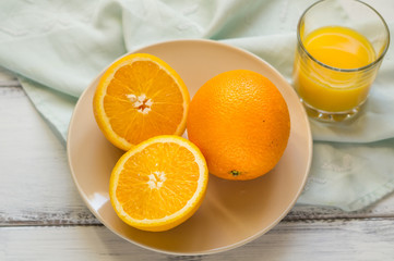 ripe oranges on a plate and orange halves