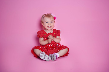 Obraz na płótnie Canvas Little girl smiling on a pink background