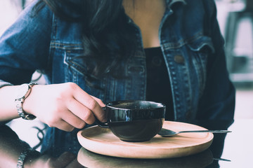 woman holding cup of hot coffee.
