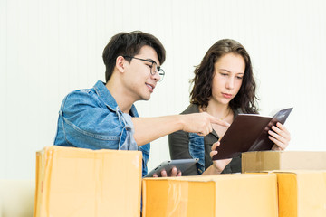 Worker In Warehouse Checking Box  Using Digital Tablet.Start up small business entrepreneur SME or freelance man and woman working  at home concept, Young Asian small business owner, online marketing.