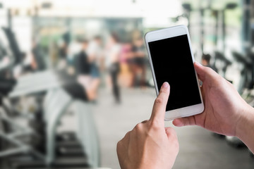 Smartphone device on fitness blur background with empty screen display.