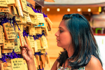 A girl looking at Japanese praying boards in Hakone shrine, Hakone, Japan