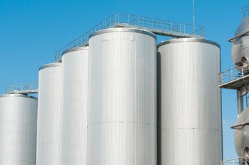 Huge barley tanks close up shot with blue sky background.