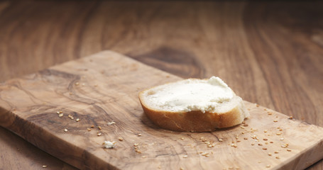 cream cheese on baguette slice on wood board