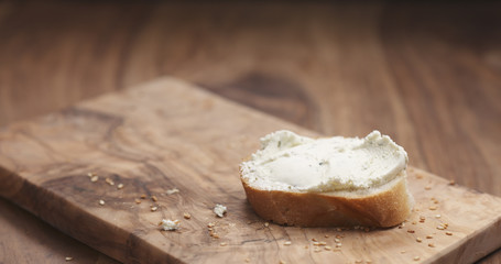 cream cheese on baguette slice on wood board