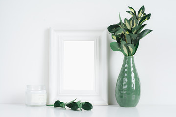 White frame mockup with yellow-green leaves and candle