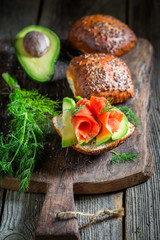 Tasty bun with avocado, dill and salmon