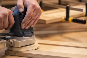 Manual manufacturing of furniture from a natural tree in a workshop.