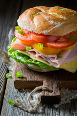 Big sandwich with tomatoes, cheese and ham