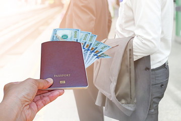 woman hand holding passport and American dollar currency isolated on blurred cars run on highway with mountain background