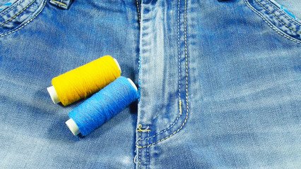 Fototapeta na wymiar Blue jeans and sewing threads.