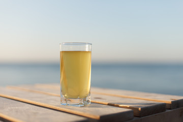 Glass of cold drink on table sunbed or table on beach