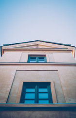 Yellow tower (belfry) in one of the old yards in the central part of the city of Lviv, Ukraine. Sunny afternoon in February. Vintage blue  and retro filters.