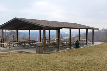 The empty picnic shelter in the park on a cloudy day.