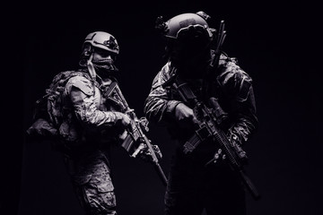 soldiers or private military contractors holding rifle. Image on a black background. war, army, weapon, technology and people concept