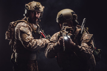Naklejka premium soldiers or private military contractors holding rifle. Image on a black background. war, army, weapon, technology and people concept