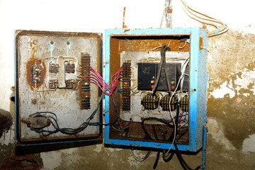 Old dismantled and rusty electrical panel assembly on an abandoned and destroyed factory against a backdrop of chaos. Destruction and vandalism. Ukraine.