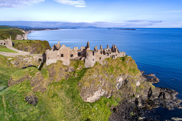 Fototapeta na wymiar Ruins of medieval Dunluce Castle, cliffs, bays and peninsulas. Northern coast of County Antrim, Northern Ireland, UK. Aerial view.