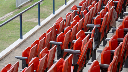 Rows of red folding chairs in the football stadium