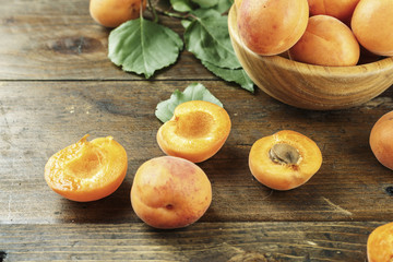 Delicious ripe apricots in a wooden bowl on the table close-up