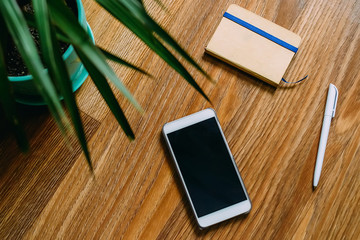 notebook, pen and phone lieing on the broune