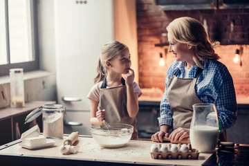 Grandmother and granddaughter cooking on kitchen - obrazy, fototapety, plakaty