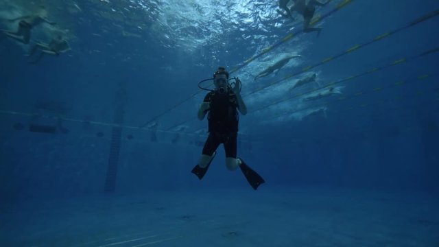 Sdiver in diving mask and diving equipment swimming underwater deep pool