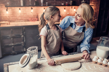 Grandmother and granddaughter cooking on kitchen