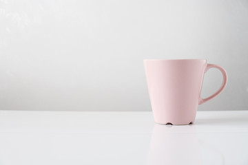 pink coffee mug on white table