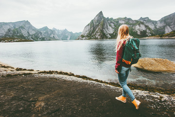 Backpacker woman walking alone in Norway lifestyle travel concept adventure outdoor summer vacations - obrazy, fototapety, plakaty
