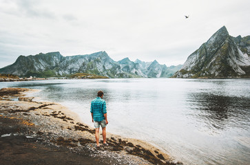 Man walking alone at fjord in Norway Travel lifestyle emotions concept summer vacations outdoor Lofoten islands scandinavian nature