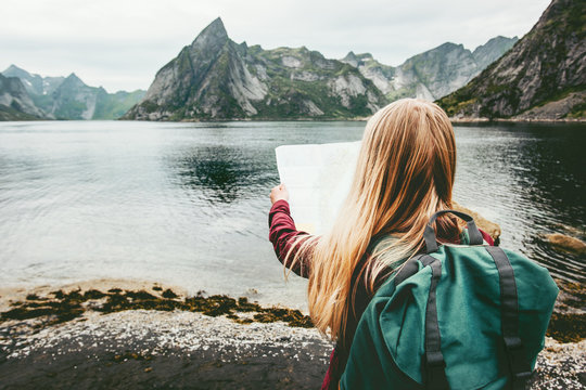 Tourist woman with map sightseeing Lofoten islands in Norway Travel lifestyle concept adventure outdoor summer vacations