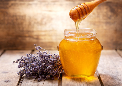 Pouring Honey Into Jar Of Lavender Honey