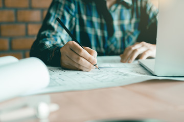 Young engineer drawing a plan at room office.