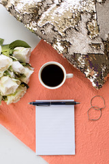 A cup of coffee and notebook on the woman's dask