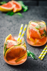 Grapefruit and rosemary alcohol free mocktail on dark concrete background. Selective focus, copy...