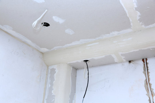 Okablowanie na suficie i ścianie, szpachlowanie płyt gipsowych.