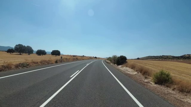 Motorcyclist Rides on a Landscape Desert scenic and empty road in Spain. First-person view. POV. Mototravel. Viewpoint of a biker riding on the asphalt road in the desert.
